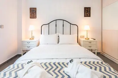 a bedroom with a large white bed with two night stands at Koukaki Home in Athens