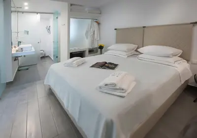 a bedroom with a white bed with towels on it at Carolina Hotel since 1934 in Athens