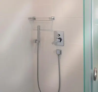 a shower in a white tiled bathroom with a hose at Carolina Hotel since 1934 in Athens