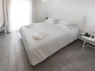 a white bed with two white towels on top of it at Carolina Hotel since 1934 in Athens