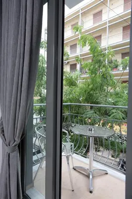 a balcony with a table and chairs and a building at Meni Apartments in Athens