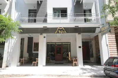 a building with an entrance with tables and chairs at Meni Apartments in Athens