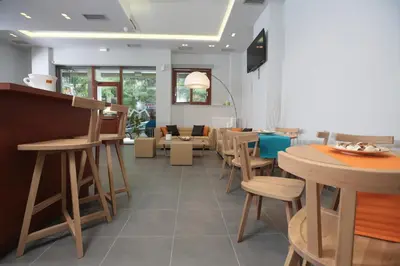 a restaurant with wooden stools and a waiting room at Meni Apartments in Athens