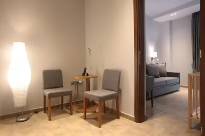 a living room with two chairs and a table and a couch at Meni Apartments in Athens