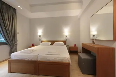 a bedroom with a large bed and a mirror at Meni Apartments in Athens