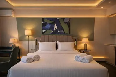 a bedroom with a large white bed with towels on it at Elite Ermou Suites in Athens
