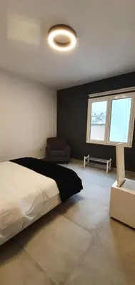 a bedroom with a bed and a chair and a window at GK Athens by GK Properties in Athens