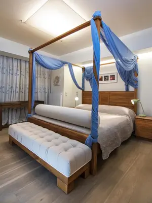 two beds in a bedroom with blue drapes at Hidden Sanctuary In Saronida in Anavissos