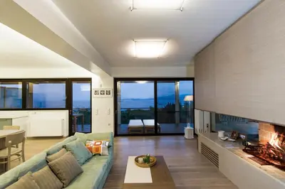 a living room with a couch and a fireplace at Hidden Sanctuary In Saronida in Anavissos