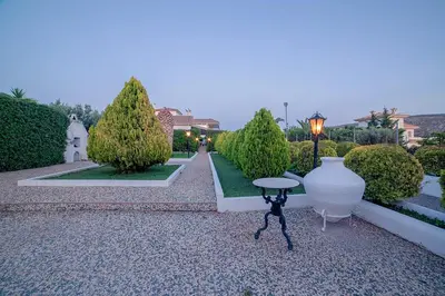 a garden with a large white vase and a table at Villa Noaina in Lagonissi in Lagonissi