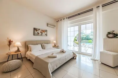 a bedroom with a bed and a large window at Villa Noaina in Lagonissi in Lagonissi