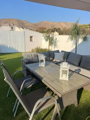 a table and chairs with a couch in a yard at Villa Noaina in Lagonissi in Lagonissi