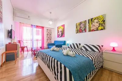 a bedroom with a bed with a blue blanket at Zenios Amintas-Pop-artment for two in city center in Athens