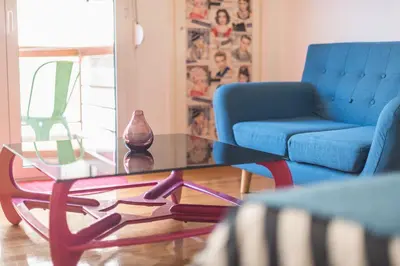 a living room with a glass coffee table and a blue couch at Zenios Amintas-Pop-artment for two in city center in Athens