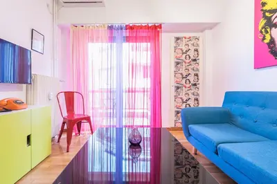a living room with a blue couch and a glass table at Zenios Amintas-Pop-artment for two in city center in Athens