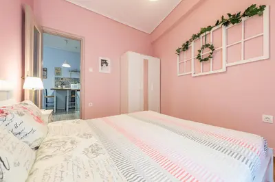 a bedroom with pink walls and a bed at Zenios Hercules - Stylish apartment near Acropolis in Athens
