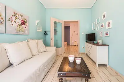 a living room with a white couch and a table at Zenios Hercules - Stylish apartment near Acropolis in Athens