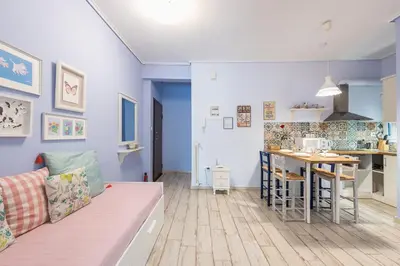 a living room with a couch and a kitchen at Zenios Hercules - Stylish apartment near Acropolis in Athens
