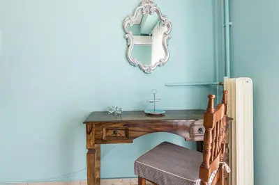 a dressing table with a mirror on a blue wall at Zenios Hercules - Stylish apartment near Acropolis in Athens