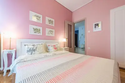 a bedroom with pink walls and a large bed at Zenios Hercules - Stylish apartment near Acropolis in Athens