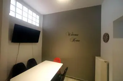 a meeting room with a table and a tv on a wall at Gazi Boutique Apartment 1 in Athens