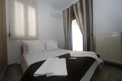 a white bed in a room with a window at Gazi Boutique Apartment 1 in Athens