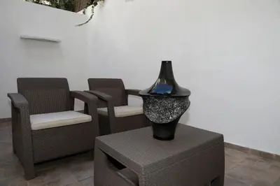 a black vase sitting on a table next to chairs at Gazi Boutique Apartment 1 in Athens