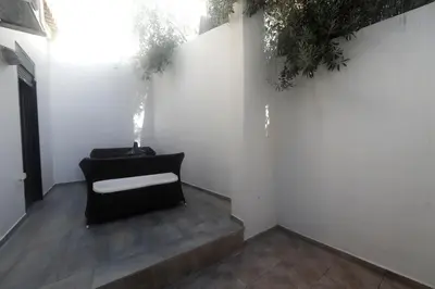 a black chair in a room with white walls at Gazi Boutique Apartment 2 in Athens