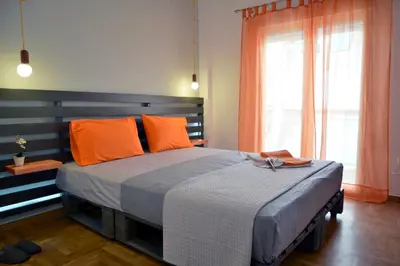 a bedroom with a large bed with orange pillows at Hidden Gem next to the Acropolis in Athens