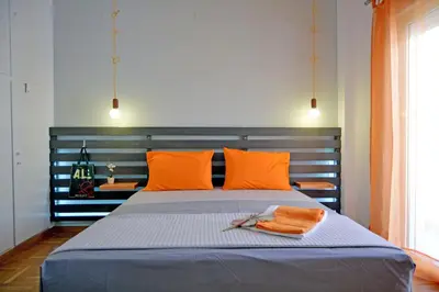 a bed with orange pillows and orange towels on it at Hidden Gem next to the Acropolis in Athens