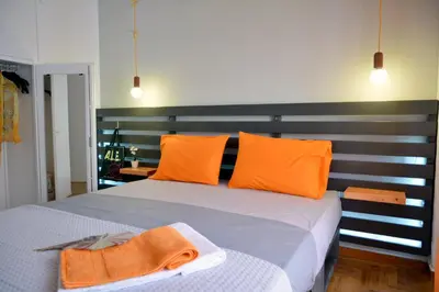 a bedroom with a large bed with orange pillows at Hidden Gem next to the Acropolis in Athens