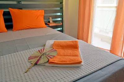 a bed with an orange towel and an umbrella at Hidden Gem next to the Acropolis in Athens