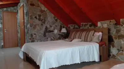 a bedroom with a bed in a stone wall at Panoramic Voula's View Apartment in Athens