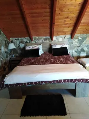 a large bed in a room with a stone wall at Panoramic Voula's View Apartment in Athens