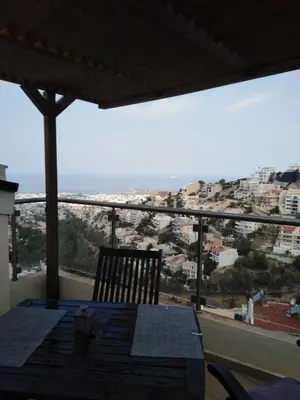a table with a chair and a view of a city at Panoramic Voula's View Apartment in Athens