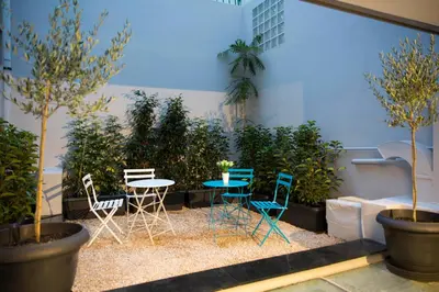 a patio with a table and chairs and plants at Pi Athens in Athens