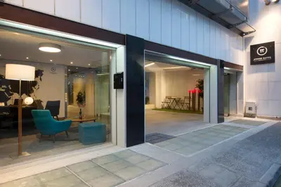 a glass entrance to a building with a blue chair at Pi Athens in Athens