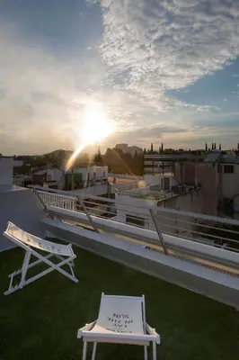 a balcony with a table and a bench on a roof at Pi Athens in Athens