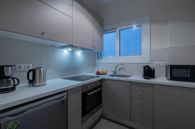 a white kitchen with a sink and a microwave at Oro's Stylish Kolonaki Flats Next to Metro & Museums in Athens
