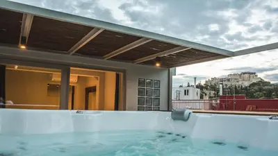 a hot tub on the balcony of a house at Acropolis Luxury Apartments in Athens