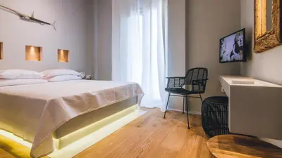 a bedroom with a bed and a chair and a window at Acropolis Luxury Apartments in Athens