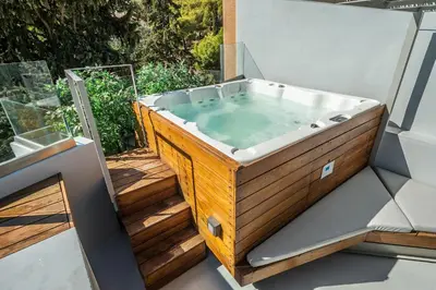 a jacuzzi tub sitting on top of a deck at Acropolis Luxury Apartments in Athens