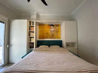 a bed in a bedroom with a painting on the wall at Plato's Academy Home in Athens