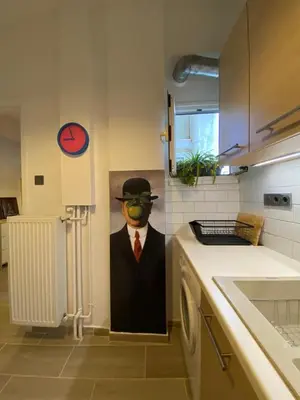 a painting of a man in a suit and hat in a kitchen at Plato's Academy Home in Athens