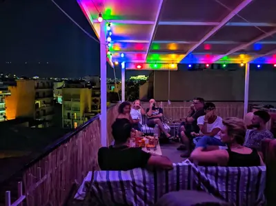 a group of people sitting on a rooftop at night at Plato's Academy Home in Athens