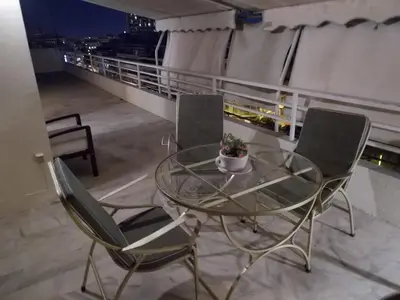a glass table and chairs on a balcony at Top Floor Studio Near Metro&View&200mbps in Athens