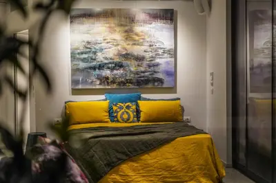 a bedroom with a bed with a painting on the wall at ApArt Suite in Athens