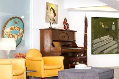 a living room with a piano and yellow chairs at ApArt Suite in Athens