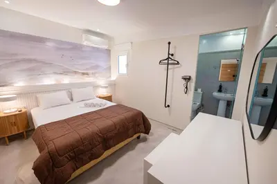 a hotel room with a bed and a bathroom at LUX Hotel in Piraeus