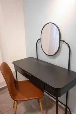 a black desk with a mirror and a chair at LUX Hotel in Piraeus